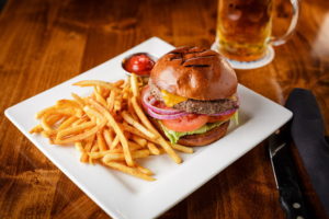 burger and fries on plate with beer